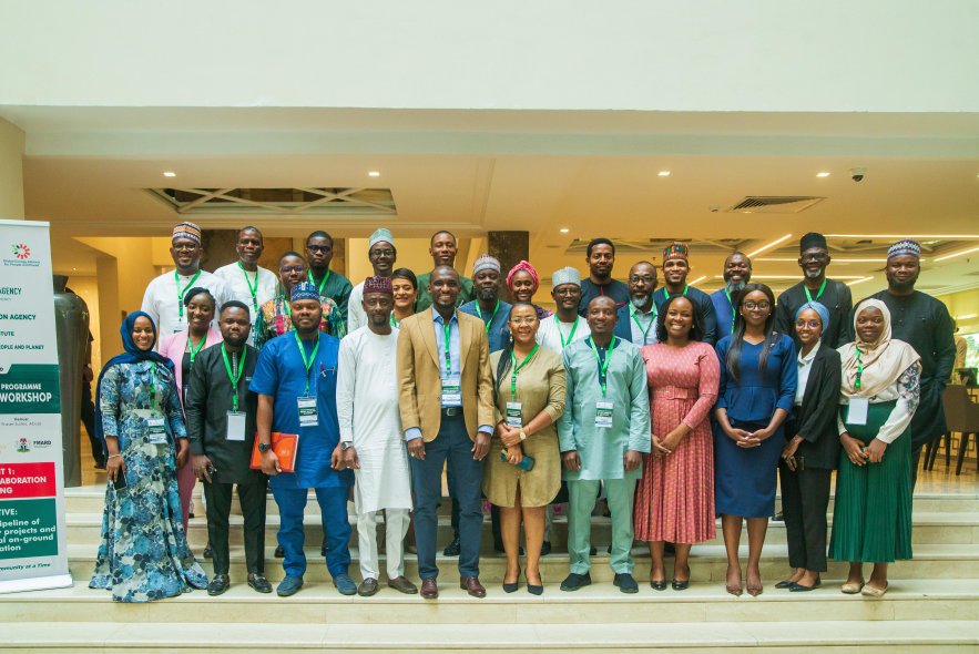 A group of Nigerian colleagues from REA, partner organizations, and RMI posing for a workshop photo.