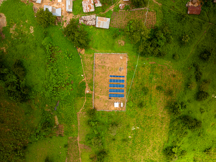 Drone shot of solar panels in a green field